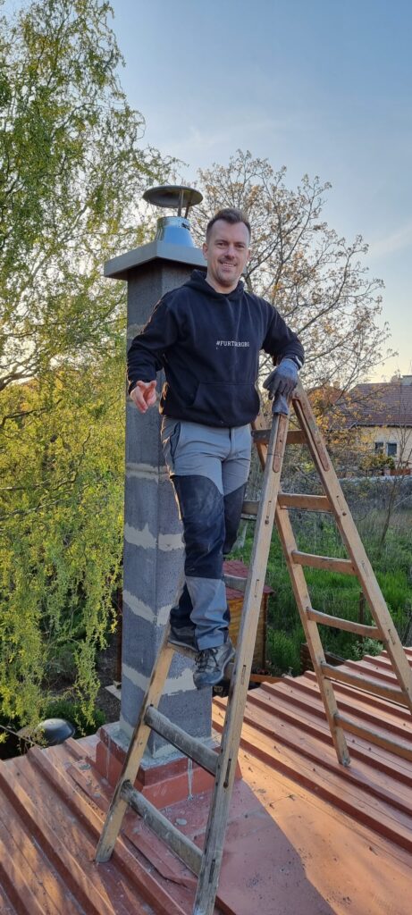 Ing. Ľuboš Hanák, kominár a revízny technik komínov, pri komíne na streche rodinného domu